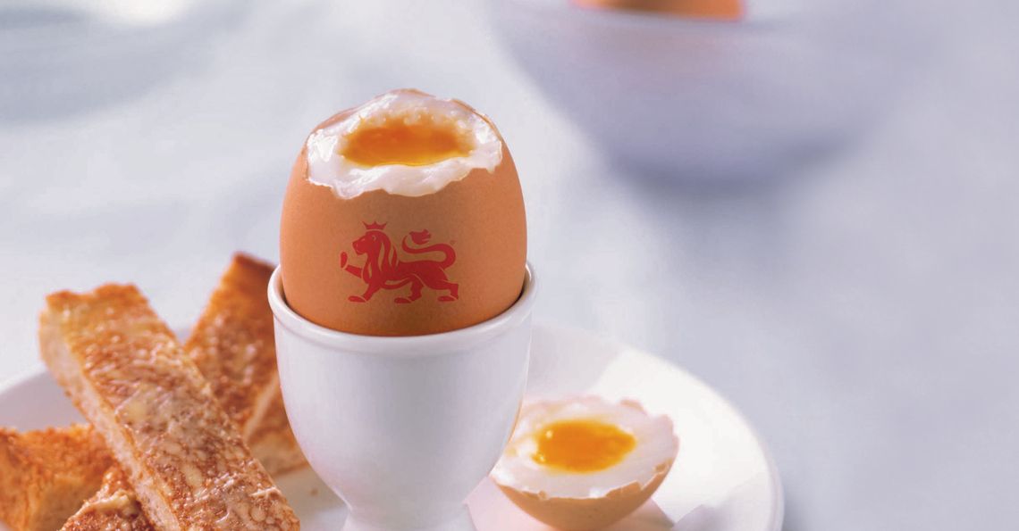 A boiled egg with a British Lion egg mark served on a plate with toast soldiers